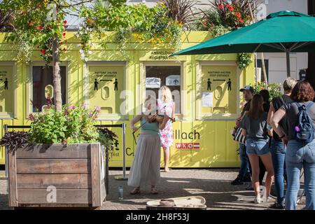 Menschen, die vor einer Freiluft-Coronavirus-Testanlage in Villach, kärnten, in Österreich, warten, um sich über covid 19 testen und verfolgen zu lassen Stockfoto