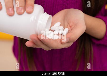 Tabletten für die orale Anwendung. Tabletten werden aus der Flasche in die Hände von Kindern verschüttet. Verschreibungspflichtige Medikamente Stockfoto
