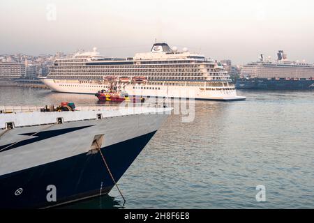 Bug eines Schiffes mit Schlepper in der Nähe eines Kreuzfahrtschiffes im Hafen von Piräus, Griechenland Stockfoto