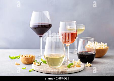 Rot, Weißwein und Rose in verschiedenen Gläsern Stockfoto