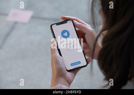 CHIANGMAI, THAILAND, 28 NOV 2021 : Frau Hand hält iPhone xs mit Social-Networking-Service Telegram auf dem Bildschirm Stockfoto