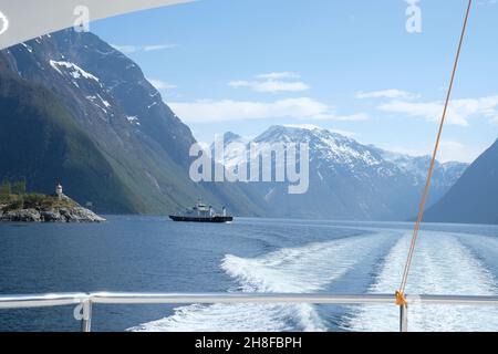 Segeln auf einer Yacht durch die Fjorde Norwegens mit Blick auf ein Boot und die Berge Stockfoto