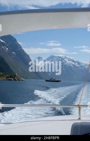 Segeln auf einer Yacht durch die Fjorde Norwegens mit Blick auf ein Boot und die Berge Stockfoto