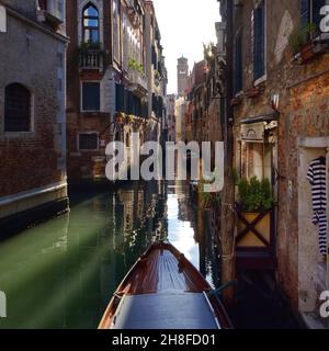 Ein typischer enger Kanal in Venedig, Italien. Ein typisches Gondolierkleid, das in einem Gewölbe hängt Stockfoto