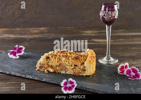 Pear Pie und Schokoladenstückchen mit essbaren Blüten in Scheiben schneiden. Französische Gourmetküche Stockfoto