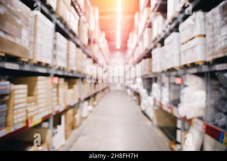 Verschwommenes Hintergrundbild Innenlager mit Karton-Einzelhandel oder Postzentrum mit Sonnenlicht. Stockfoto