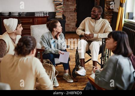 Gruppe von Studenten treffen sich im Klassenzimmer, um zukünftige Prüfungen zu besprechen, sie sitzen im Kreis und sprechen Stockfoto