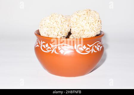 Indische Süßigkeit für traditionelles Festival makar sankranti :Rajgira laddu aus Amaranth Samen in Schale auf weißem Hintergrund Stockfoto