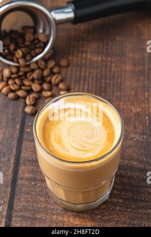 Cortado-Kaffee mit Kaffeebohnen daneben. Traditioneller Kaffee in Spanien. Stockfoto