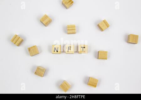 Wort NFT (nicht fungible Token) auf den Holzwürfeln auf weißem Hintergrund geschrieben. Nicht-fungible Token Konzept NFT. Stockfoto