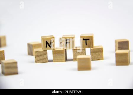 Wort NFT (nicht fungible Token) auf den Holzwürfeln auf weißem Hintergrund geschrieben. Nicht-fungible Token Konzept NFT. Stockfoto