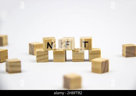 Wort NFT (nicht fungible Token) auf den Holzwürfeln auf weißem Hintergrund geschrieben. Nicht-fungible Token Konzept NFT. Stockfoto