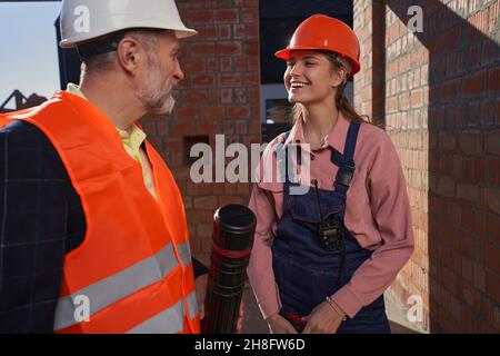 Zwei professionelle Ingenieure unterhalten sich in der Nähe des Gebäudes Stockfoto