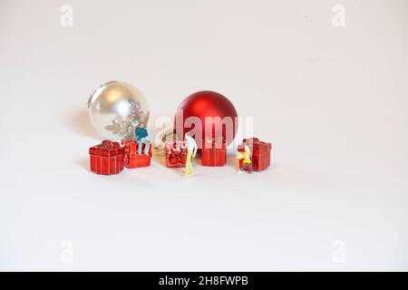 Die Auswahl von Weihnachtsgeschenken kann schwierig sein. Diese kleinen Miniaturfiguren repräsentieren das. Selektiver Fokus. Stockfoto