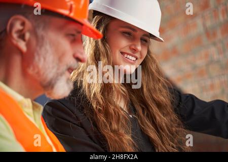 Ehrgeizige junge Dame und reifer Architekt arbeiten zusammen Stockfoto
