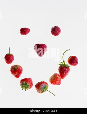 Eine Studioaufnahme eines Smiley-Gesichts aus Erdbeeren, isoliert auf weißem Hintergrund Stockfoto