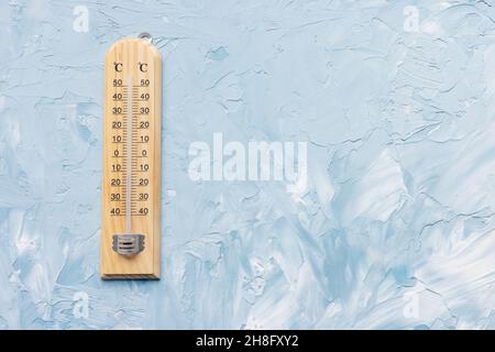 Das Thermometer zeigt niedrige Temperaturen auf weißem und blauem Hintergrund an. Winter- und Urlaubswetterkonzept, Platz kopieren Stockfoto