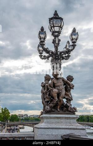 Kunstvolle klassizistische Straßenbeleuchtung mit drei Cherub auf der Brücke Alexandre III, Paris, Frankreich Stockfoto