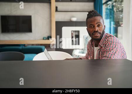 Beschaulicher afroamerikanischer Freiberufler, der am Laptop sitzt Stockfoto
