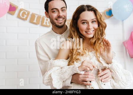 Eine glückliche, schwanger Frau und ein liebevoller Mann umarmten den Bauch und feierten die Babydusche Stockfoto