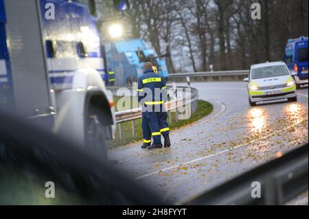 Padenstedt, Deutschland. 30th. November 2021. Die Rettungskräfte des Technischen Hilfswerks (THW) stehen auf der Zufahrtsstraße. Ein mit 22 Tonnen Schweinehälften beladener LKW durchbrach auf der Zufahrtsstraße von der B 205 zur B 7 bei Neumünster-Süd eine Leitplanke und ließ die Zufahrtsstraße stundenlang schließen. Quelle: Jonas Walzberg/dpa/Alamy Live News Stockfoto