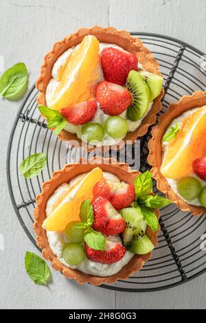 Hausgemachte Mini-Tarte mit verschiedenen Früchten. Dessert mit süßem Obst. Tarte mit Obst und Creme. Stockfoto