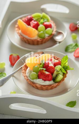 Hausgemachte Mini-Tarte mit verschiedenen Früchten. Einfaches Sommerdessert. Tarte mit Obst und Creme. Stockfoto