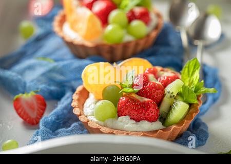 Süße Mini-Tarte mit verschiedenen Früchten. Dessert mit süßem Obst. Tarte mit Obst und Creme. Stockfoto