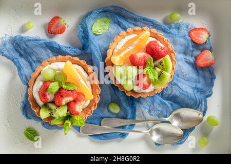 Süße Mini-Tarte mit verschiedenen Früchten. Einfaches Sommerdessert. Tarte mit Obst und Creme. Stockfoto