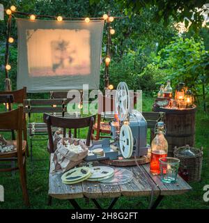 Gemütliches Sommerkino mit Vintage-Projektor am Abend Sommerkino im heimischen Garten. Stockfoto