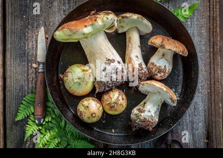 Frischer Boletus und Zwiebel auf der Pfanne. Edle Pilze auf der Pfanne. Rustikale Küche. Stockfoto