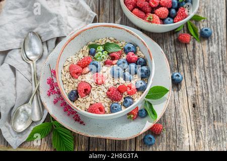 Gesundes Müsli mit Milch und Beeren. Frühstück im Sommergarten. Gesundes und leckeres Frühstück. Stockfoto