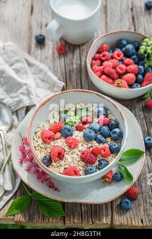 Gesundes Müsli mit Blaubeeren und Himbeeren. Flocken mit Beeren. Gesundes und leckeres Frühstück. Stockfoto