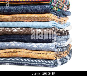 Stapel von gefalteten verschiedenen Strickpulvern und Pullovern in einem Bekleidungsgeschäft oder in einer Garderobe aus nächster Nähe Stockfoto