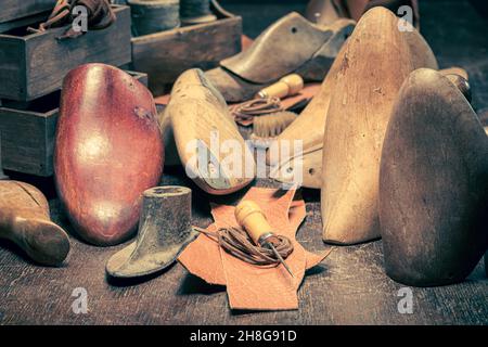 Vintage Schuster Arbeitsplatz mit Werkzeugen, Regeln, Leder und Riemen. Vintage Schuster Arbeitsplatz Stockfoto