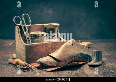 Alte Schuhmacherwerkstatt mit Werkzeugen, Regeln, Leder und Riemen. Alte Schuhmacherwerkstatt Stockfoto