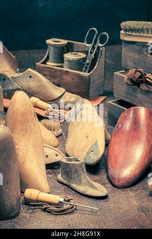 Vintage Schuhmacher-Werkstatt mit Werkzeugen, Regeln, Leder und Riemen. Werkstatt für Vintage-Schuhmacher Stockfoto