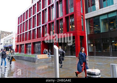 Menschen, die an der roten Außenfassade des Gebäudes vor der Bloom-Straße 48-50 Cowcross Street in der Nähe der Farringdon Station Clerkenwell London EC1 UK KATHY DEWITT vorbei gehen Stockfoto