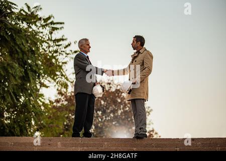 Zwei ältere Geschäftsleute schütteln sich die Hände über den Deal, aus nächster Nähe Stockfoto