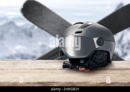 Skihelm mit Visier auf Berge Hintergrund. Moderner grauer Helm mit Sonnenblende auf Berge Hintergrund. Wintersport-Helm. Mountain Resort. Kopie Stockfoto