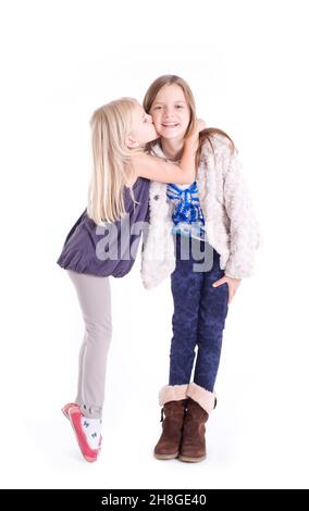 Kleines Mädchen küsst ihre ältere Schwester Stockfoto