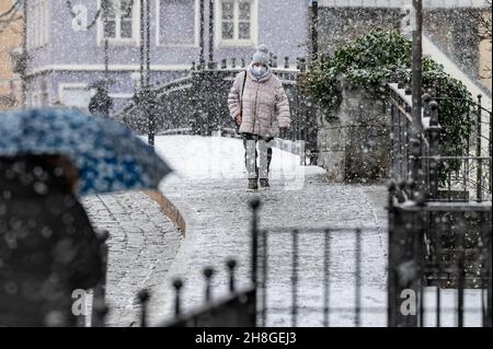 Vilshofen, Deutschland. 30th. November 2021. Eine Frau geht während eines Schnees durch das Stadtzentrum. Der Winter ist in Bayern mit Eis und rutschigen Bedingungen angekommen. Quelle: Armin Weigel/dpa/Alamy Live News Stockfoto