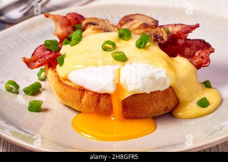 Egg Benedict mit gebratenem Speck und Sauce Hollandaise Stockfoto
