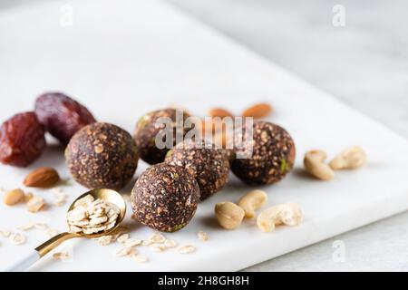 Rohe vegane Energiebälle mit Datteln, Nüssen und Hafer. Rohe vegane Schokoladentrüffel Stockfoto