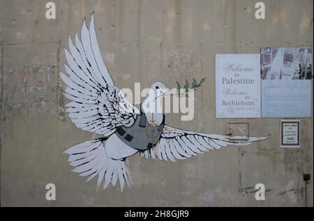 Banksy grafitti einer Taube in Körperpanzerung an einer Gebäudewand. Stockfoto