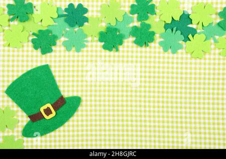 Flach Happy St. Patrick's Hintergrund mockup von handgemachtem Filz shamrock clover Blätter und Hut auf grün Serviette Stockfoto