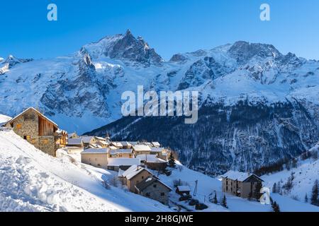 Sonnenuntergang im Dorf Chazelet mit Blick auf den Gipfel des La Meije (Ecrins National Park Massif) im Winter. Skigebiet in den Hautes-Alpes (Alpen). Frankreich Stockfoto