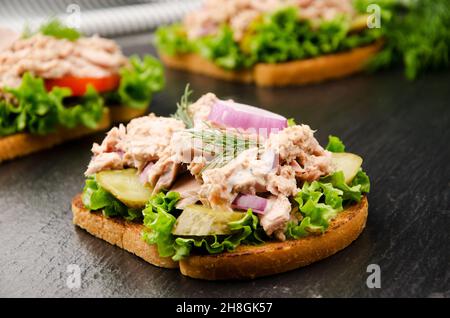 Thunfisch Sandwich mit Salat Tomaten, Gurken und Zwiebeln auf Schiefer Stockfoto