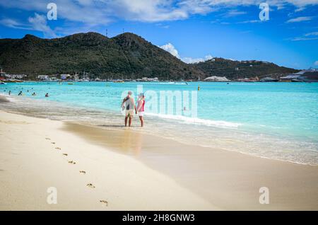 Zwei Urlauber stehen an einem wunderschönen weißen Sandstrand in der Karibik, Stockfoto