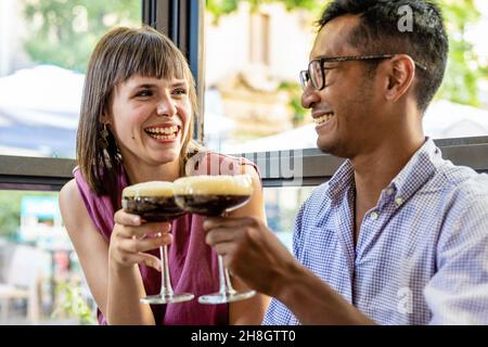 Glückliches junges Paar in einer Bar entspannen einen kalten Kaffee trinken, junge Liebhaber einander, Liebe und Zärtlichkeit, Beziehungskonzept Stockfoto